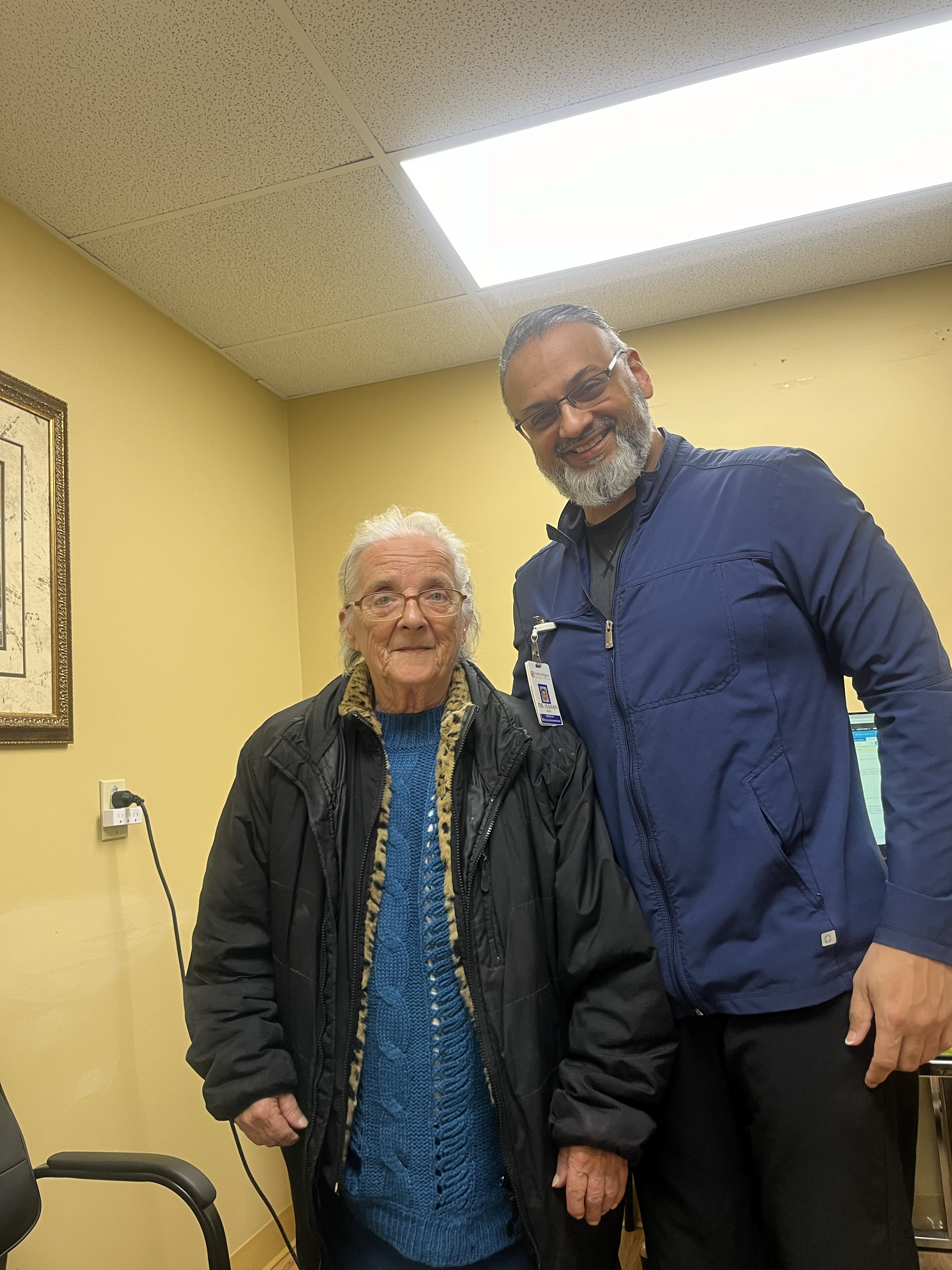 Dr. Syed Hasan with an elderly patient in a clinical office