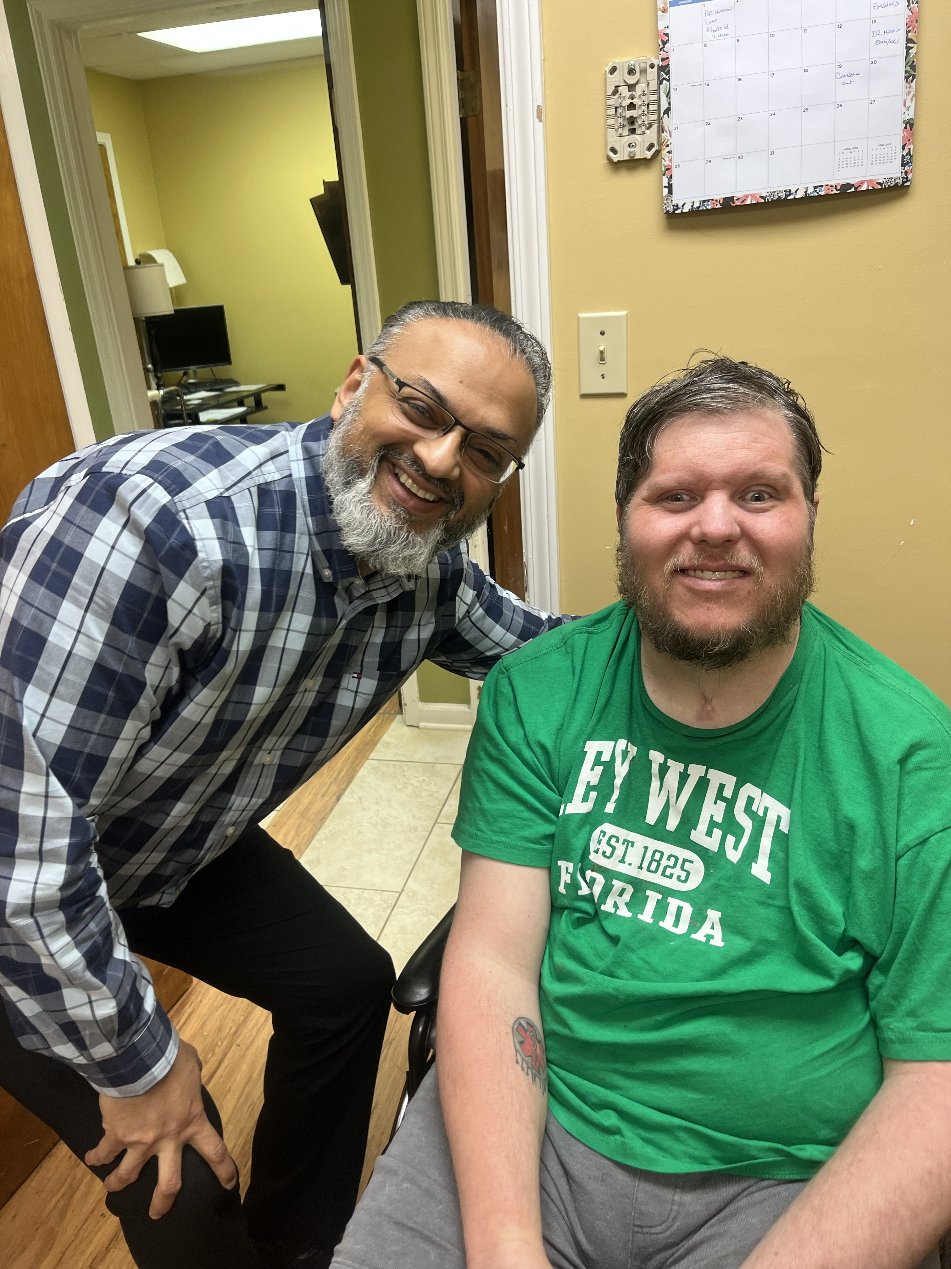 Dr. Syed Hasan with a patient in a wheelchair at a rehab clinic